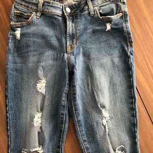 Skinny mid rise jean with distressing all down leg